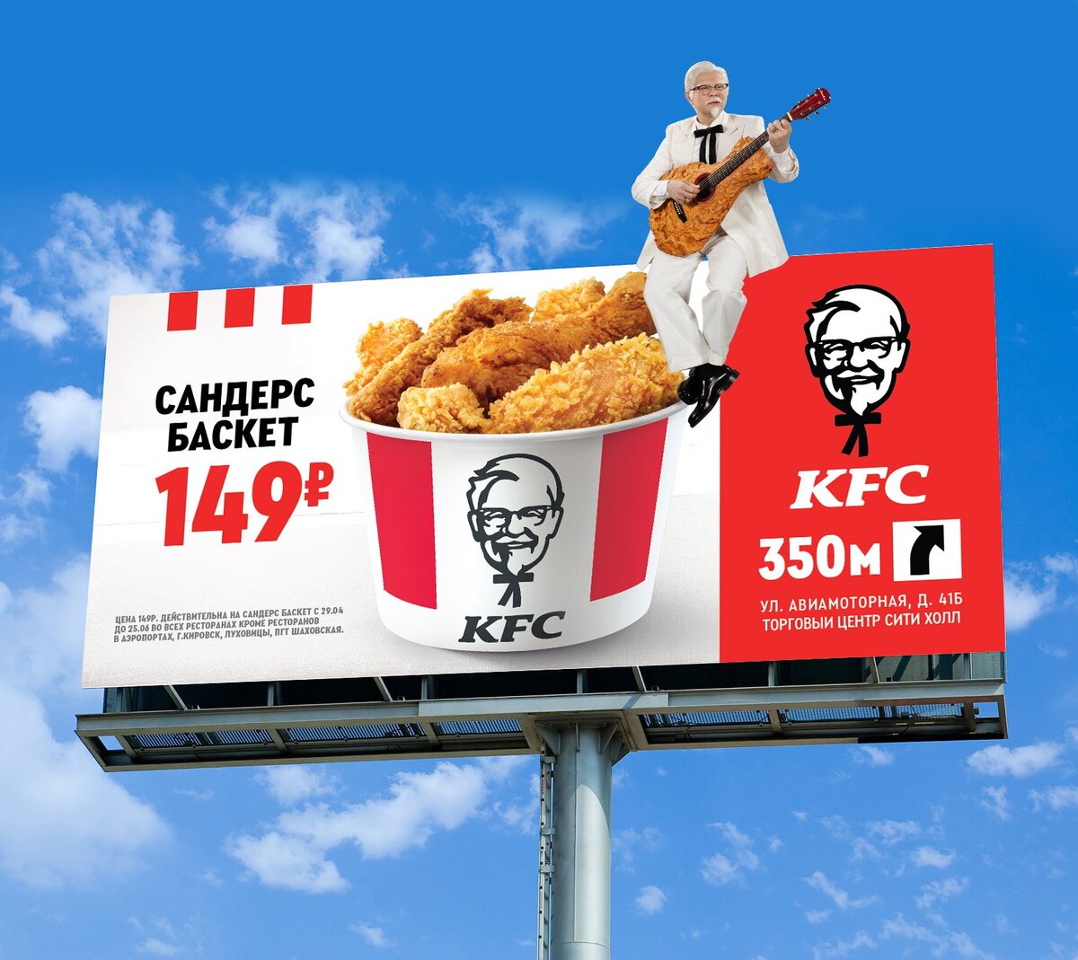 Креативная наружная реклама KFC демонстрирует полковника Сандерса, играющего на гитаре над ведром с куриными кусочками, рекламируя "Сандерс Баскет" за 149 рублей и указывая расположение ресторана в 350 метрах. 