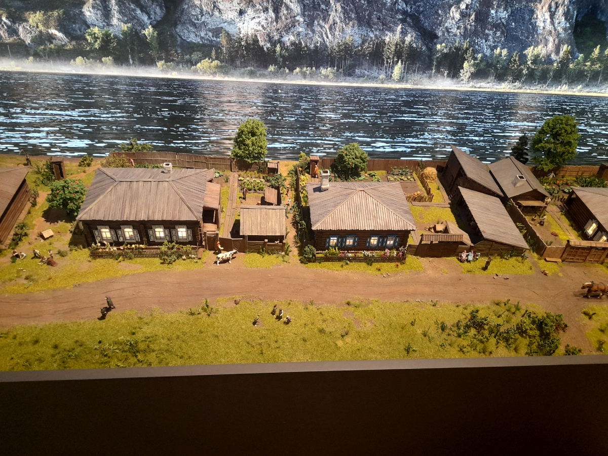 Муляж села Овсянка на фоне фотографии Енисея