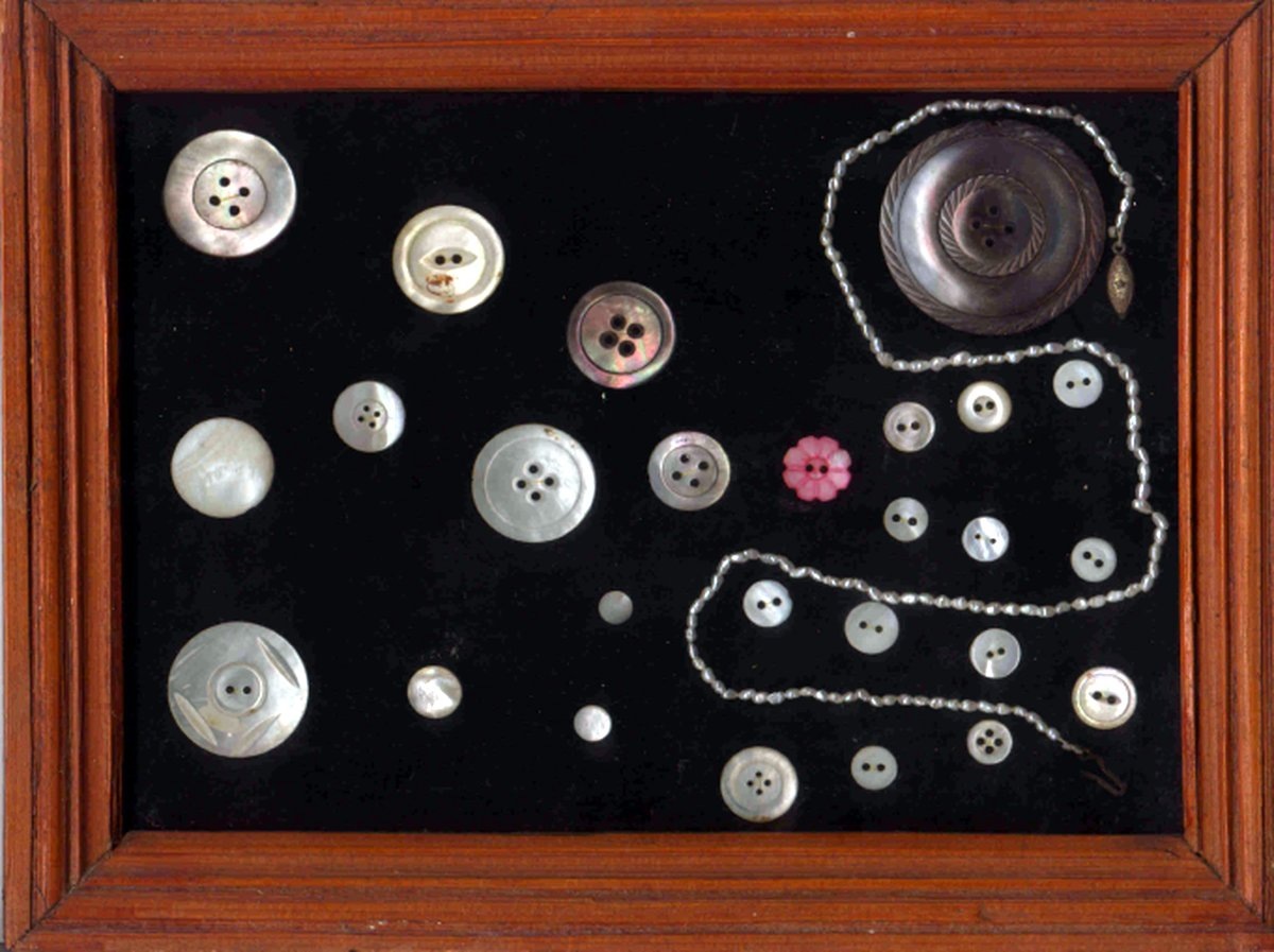 Эта рамка с перламутровыми пуговицами висит на стене возле моего стола.
