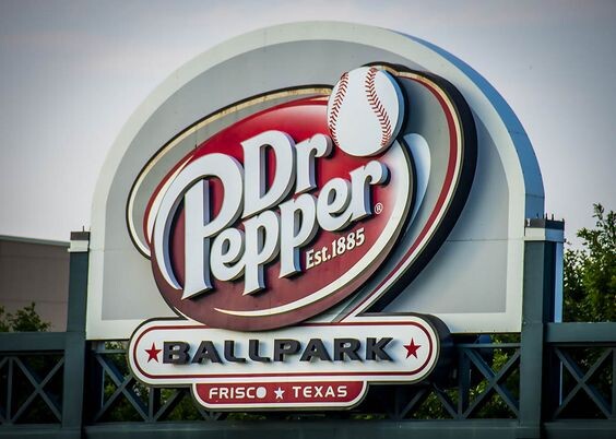 Эта креативная наружная реклама Dr Pepper представляет собой яркую вывеску на стадионе в Фриско, штат Техас, совмещающую логотип напитка и бейсбольный мяч. 