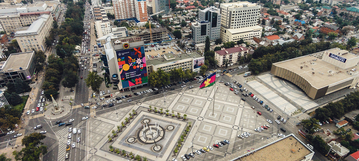 Театральная площадь: квадрат фонтана обставлен бочками с деревьями и стоят лавочки.