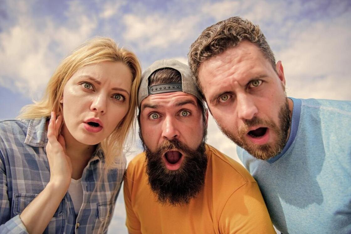    Люди с удивлением смотрят в объектив камеры:Freepik