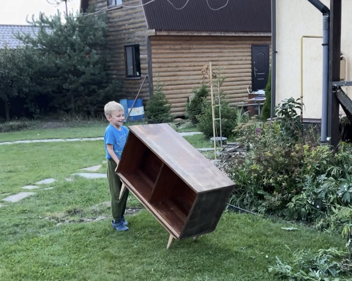 Сын катит тумбу к месту ремонта