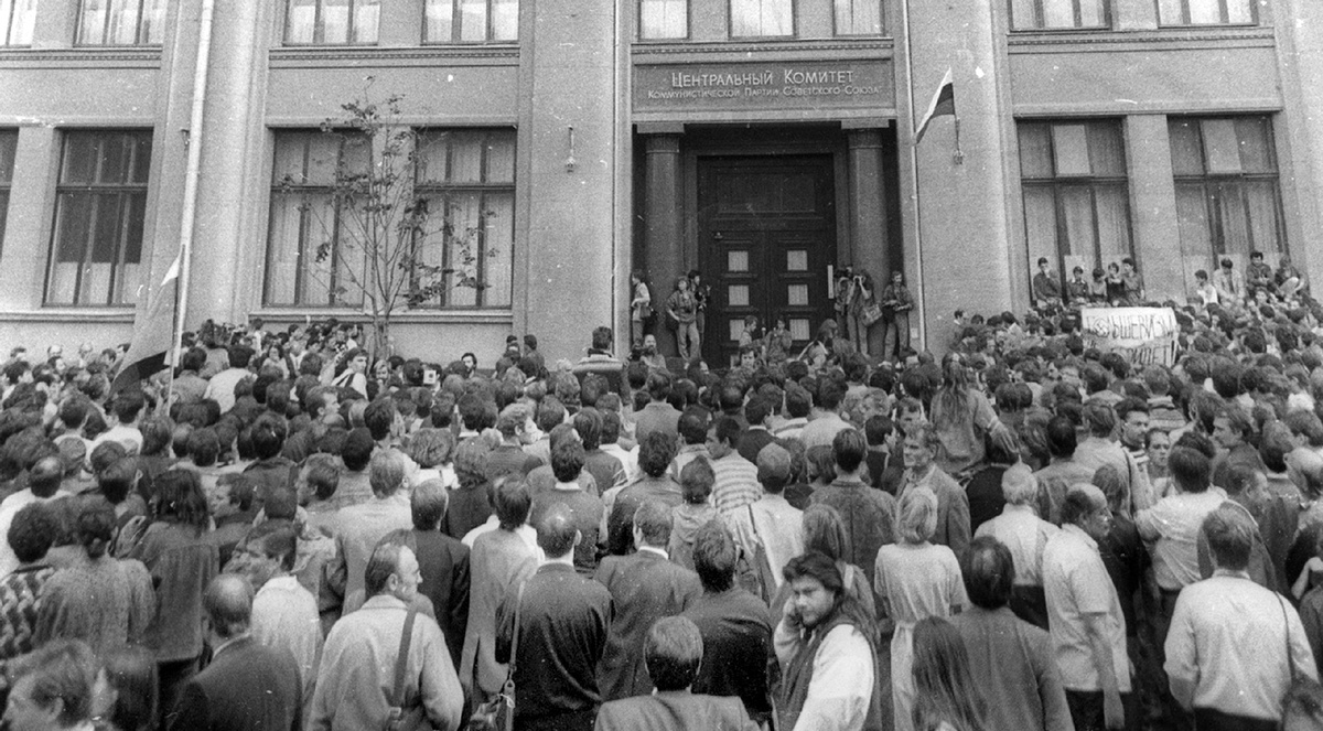 23 августа 1991 года. Толпа перед зданием ЦК КПСС. На плакате надпись: «Большевизм не пройдёт!» и над входом уже развевается флаг России.