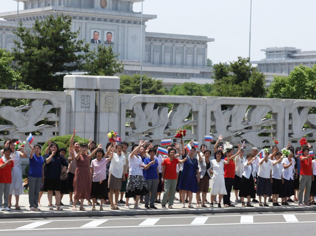    Люди приветствуют кортеж президента РФ Владимира Путина на улице в Пхеньяне© РИА Новости / POOL/Гавриил Григоров