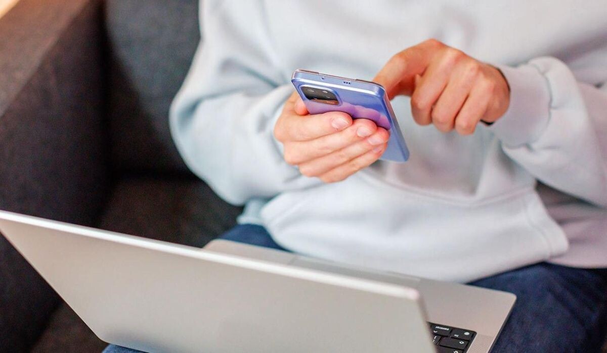     Человек с телефоном и ноутбуком. Источник: mos.ru Автор фото: Пресс-служба Мэра и Правительства Москвы