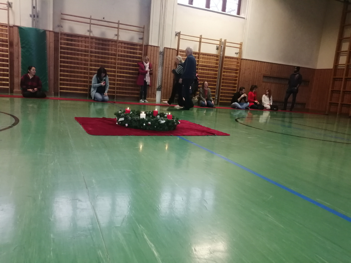 Посередине рождественский венок.Некоторые родители в одежде, так как было реально холодно.