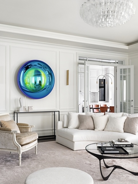 Выразительный контраст в гостиной составляют классические кресла Massant и легкий футуристичный столик Tom Faulkner с основанием из черного металла и прозрачной столешницей. Возле стены — консоль с мраморной столешницей, Tom Faulkner. Ярким акцентом стало неоново-синее «Зеркало» от Christophe Gaignon.