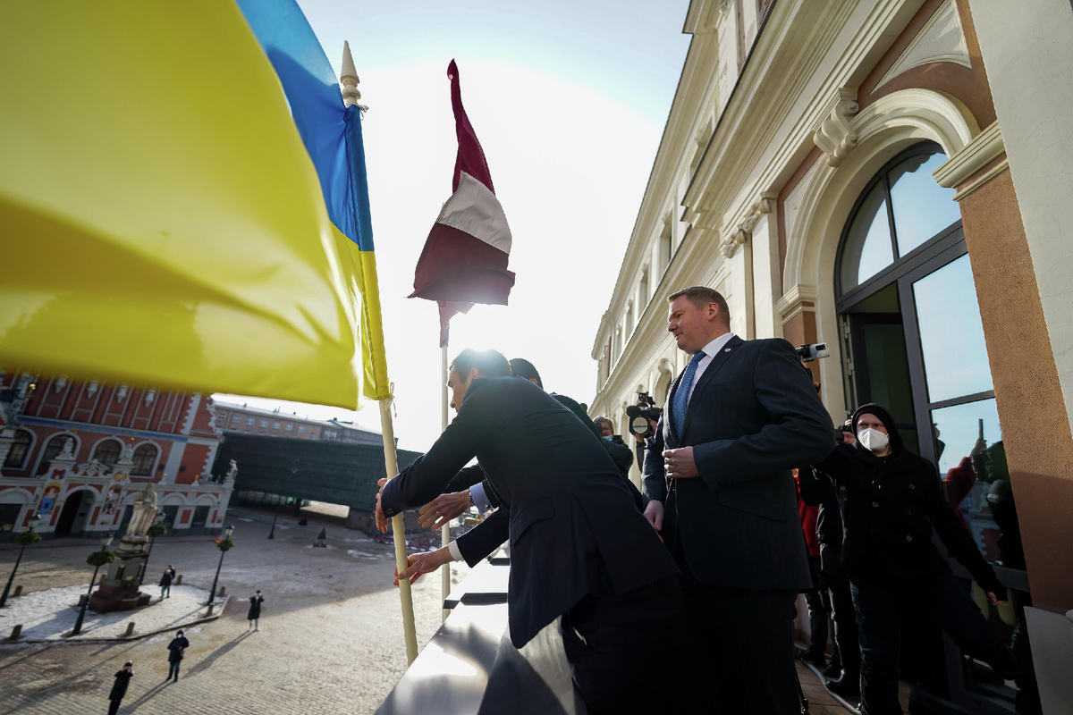 На здание Рижской думы водружают украинский флаг в знак поддержки. Фото 2022 года © Sputnik