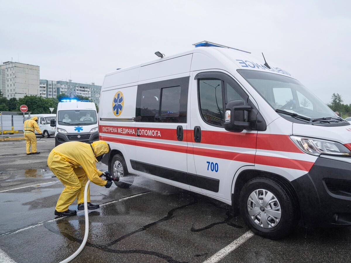    Дезинфекция автомобиля скорой помощи на Украине© AP Photo / Evgeniy Maloletka