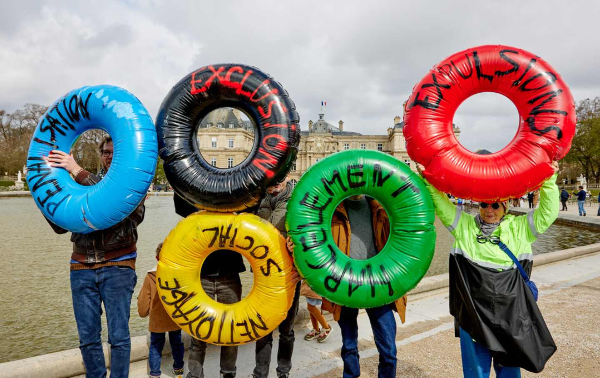 Коллектив Le Revers de la Medaille («Другая сторона медали») во время акции протеста 24 марта против социального неравенства, усугубляемого предстоящими Олимпийскими играми 2024 года в Париже. (Аднан Фарзат / NurPhoto через Getty Images)