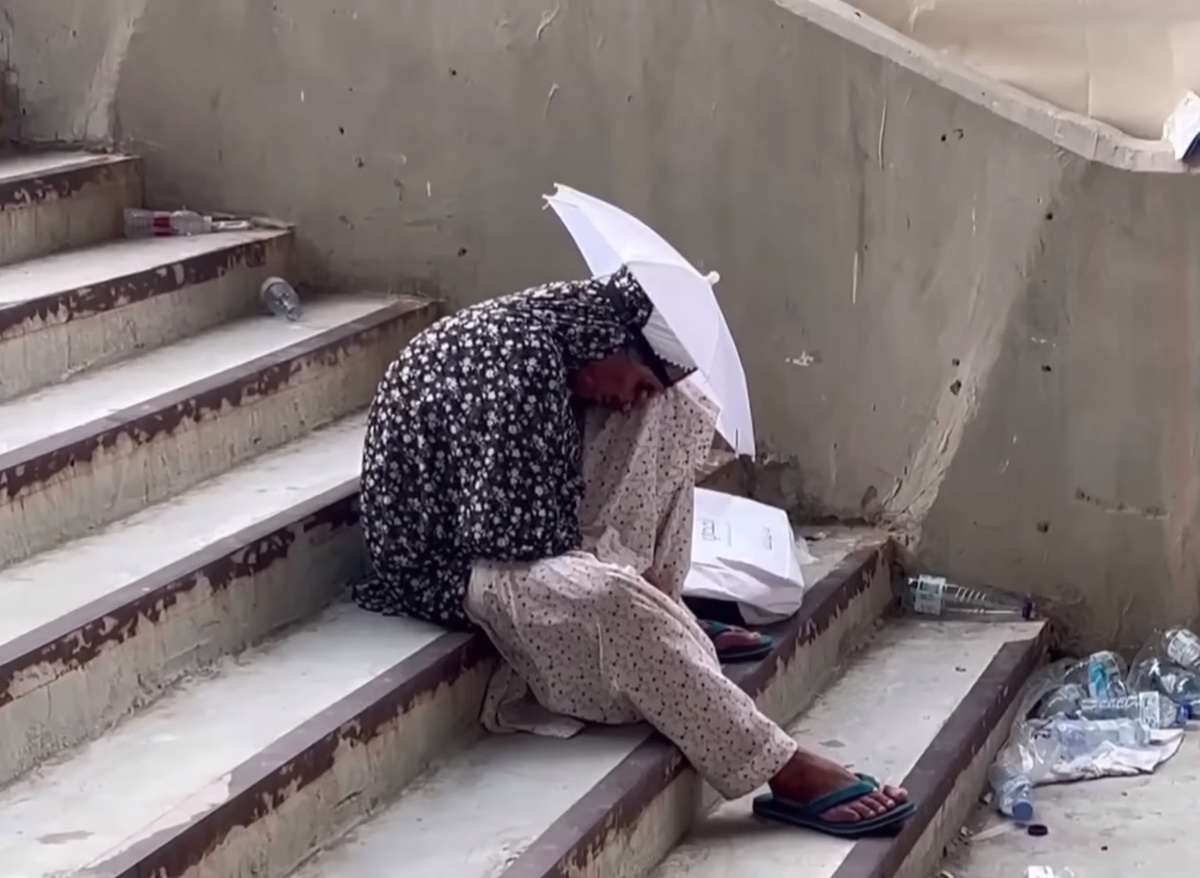 Паломница с зонтом отдыхает на лестнице