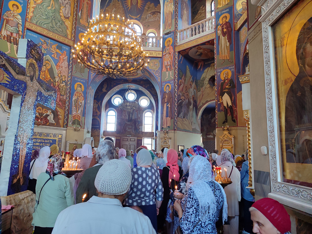 Многие молящиеся стоят со свечами...