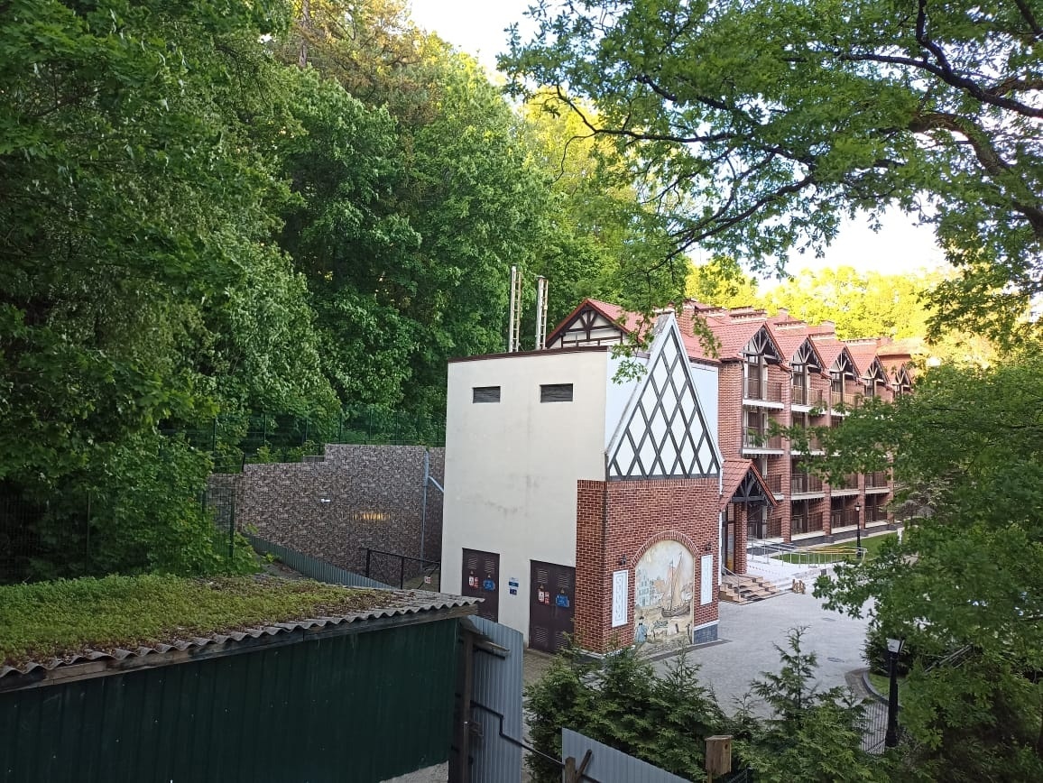 Говорят, человек из окна своей квартиры должен видеть хотя бы одно дерево. Я вижу лес и псевдонемецкие домики. Слева - зеленая крыша!