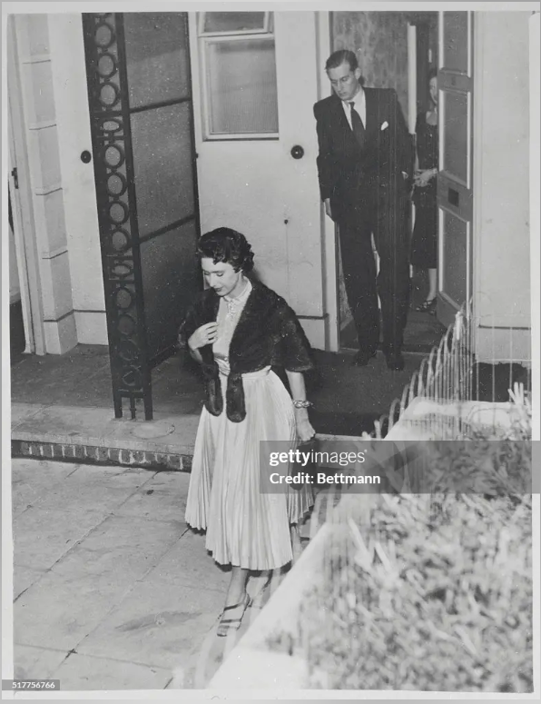 Принцесса Маргарет покидает лондонский дом подруги после второго за 12 часов свидания с капитаном группы Питером Таунсендом. Их хозяин, Джон Лоутер, справа. Маргарет и Таунсенд, которые накануне вечером провели вместе 90 минут в Кларенс-хаусе, воссоединились на утренней встрече в доме миссис Дженнифер Лоутер, бывшей фрейлины принцессы. Эти два свидания последовали за конференцией Маргарет на выходных с ее сестрой, королевой Елизаветой II, и придали вес предположениям о том, что принцесса, возможно, решила выйти замуж за разведенного простолюдина.