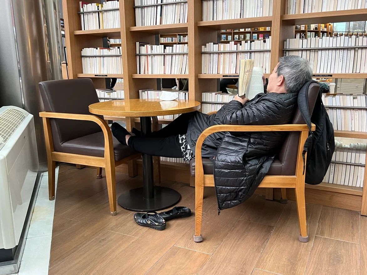 Сеульская бабушка читает книгу в библиотеке Starfield Library. Фото автора