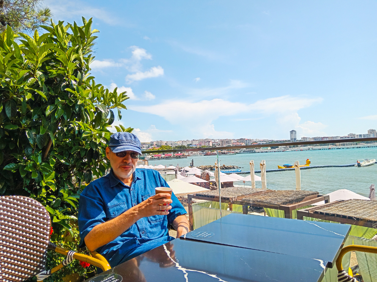 Михаил Лекс — автор рассказа и канала — в кафе с видом на Чёрное море, Геленджик, центр.