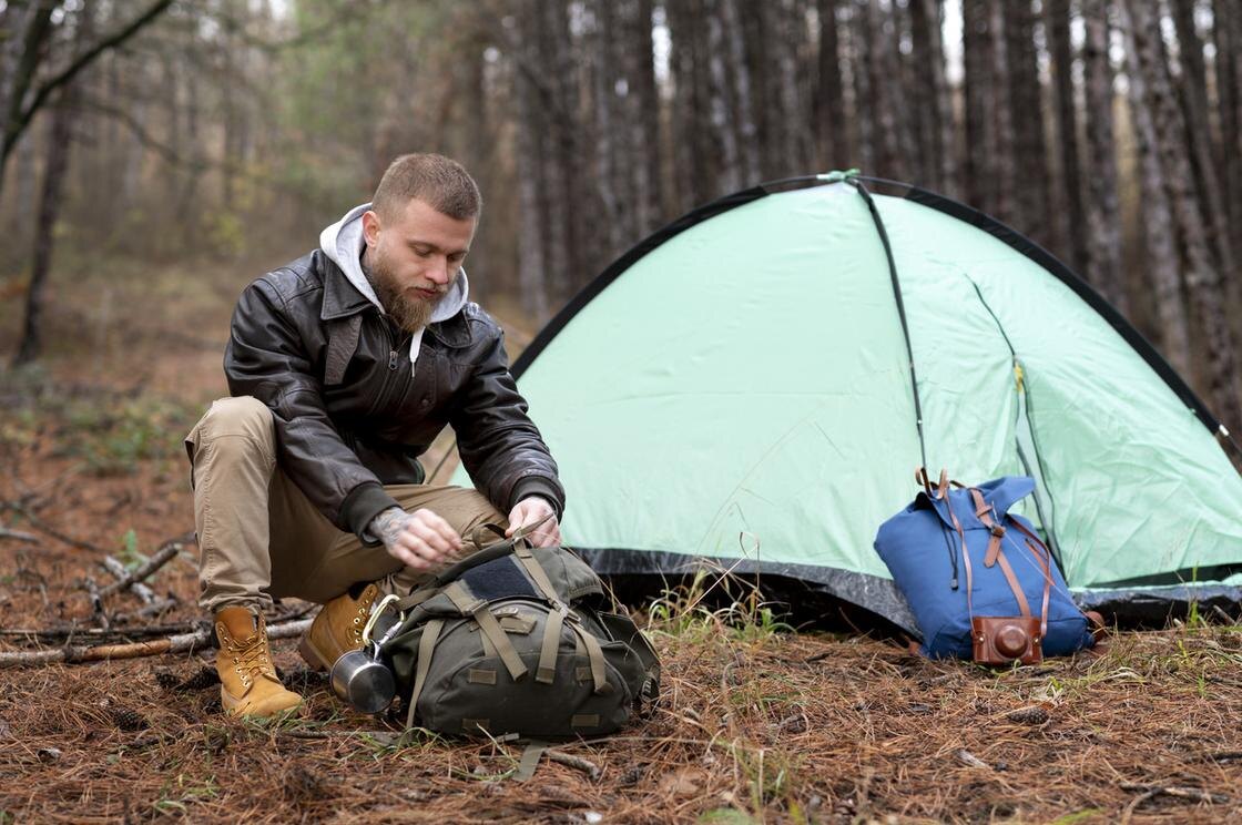    Молодой человек с бородой открывает рюкзак:iStockphoto