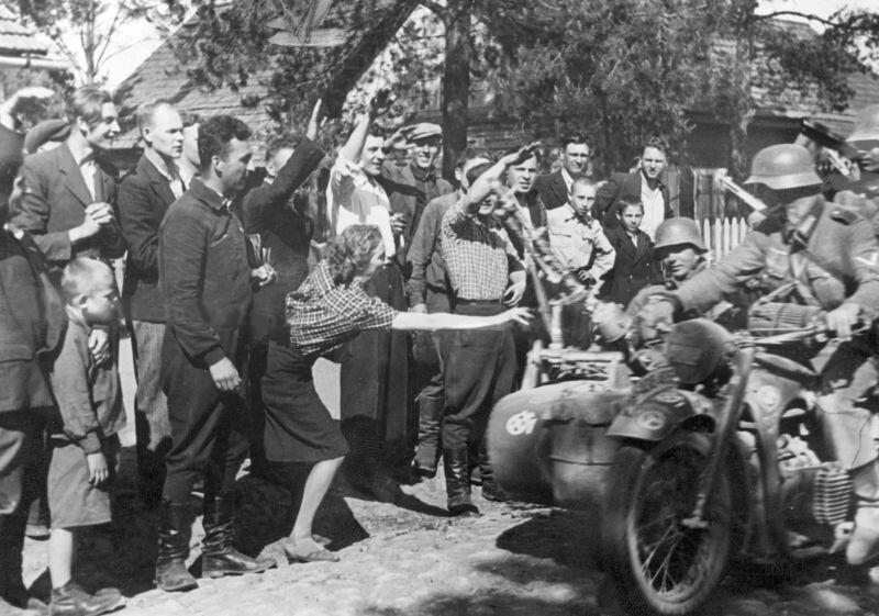 Жители литовской деревни приветствуют мотоциклистов 12-ой танковой дивизии вермахта, 26 июня 1941 года. Все иллюстрации демонстрируются исключительно в исторических целях.