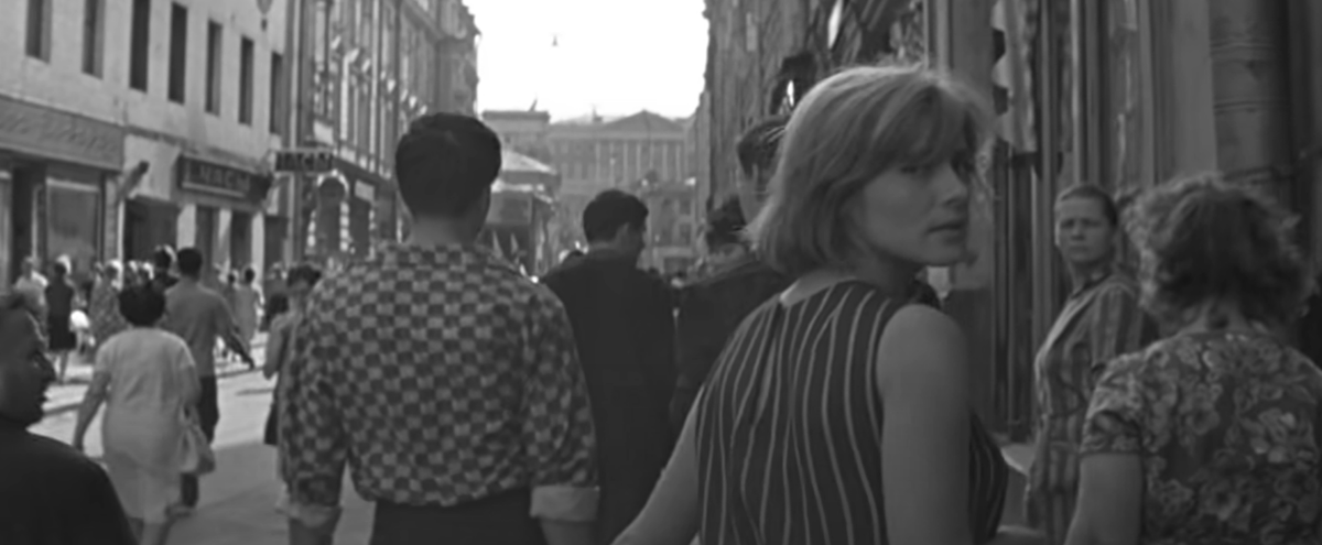 Кадр из фильма «Июльский дождь»: «Как и многие из тех, кто идет рядом с ней по утренней улице, она [Лена] живет в одном конце города, а работает в другом. Ей еще предстоит потрястись в утренней сутолоке троллейбуса, потом ехать в метро, где пассажиры, повинуясь давней привычке, не замечая ни станций, ни скорости, ни лиц соседей, развернули газеты и углубились в утренние новости.» (из сценария)