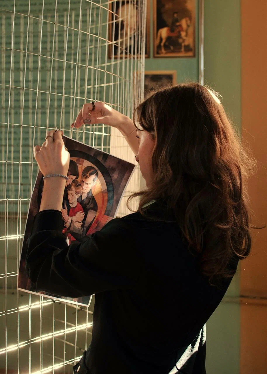 Анастасия Егорова в процессе подготовки выставки к открытию. В ее руках плакат Константина Варфоломеева, который занял 2-ое место в голосовании «Лучший плакат социальной рекламы»