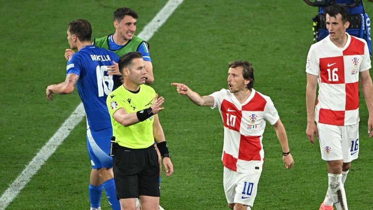    Данни Маккели и Лука Модрич спорят после матча. Reuters