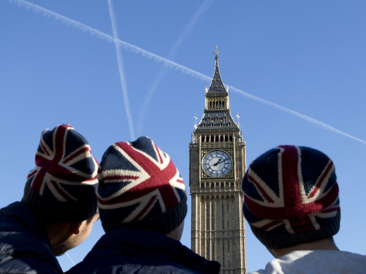    " Мужчины в шапках с флагом Великобритании у здания парламента в Лондоне© AFP / Isabel Infantes