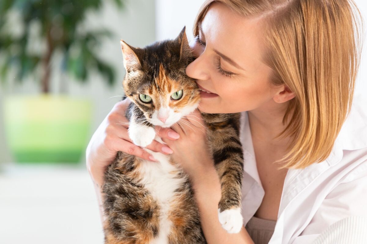 Женщина целует кошку 