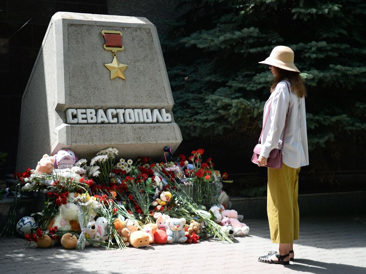    Женщина возле стихийного мемориала у стелы Севастополя на Аллее городов-героев в день траура по погибшим в результате ракетной атаки ВСУ© РИА Новости / Константин Михальчевский