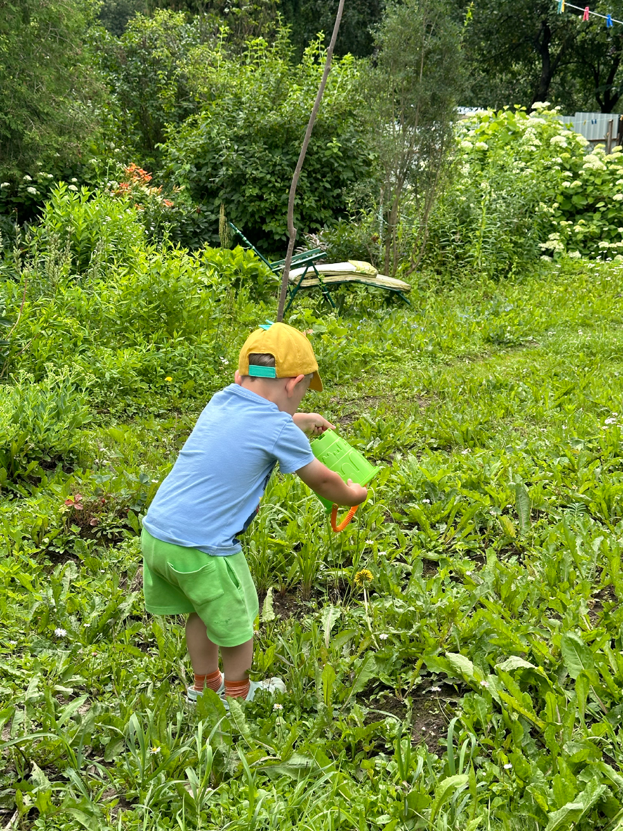 Делать куличи из такого большого ведра Тимохе пока неудобно, а вот поливать — в самый раз!
