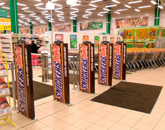 Вход в этот магазин охраняют гигантские батончики Snickers, явно намекая, что шоппинг без шоколада — это не шоппинг. 