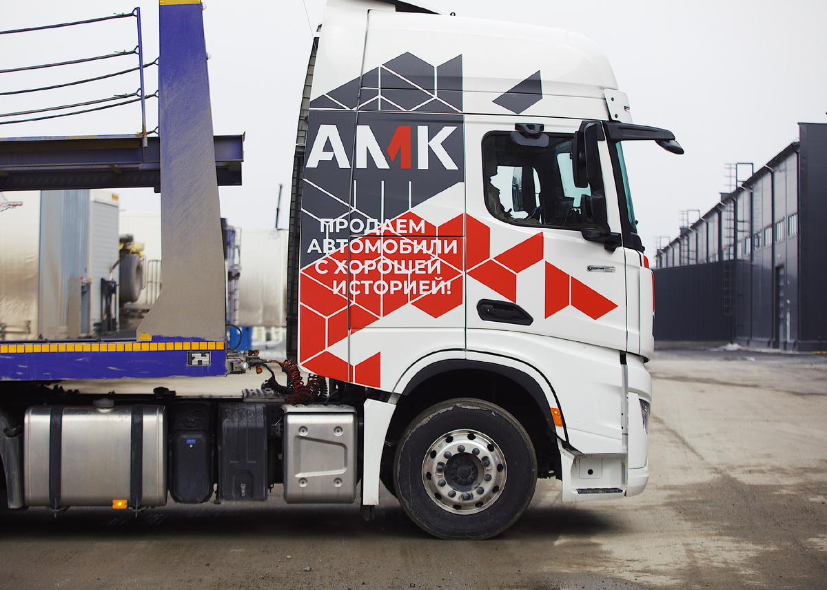 Логотип АМК на брендированном Шахмане с полуприцепом для перевозки автомобилей