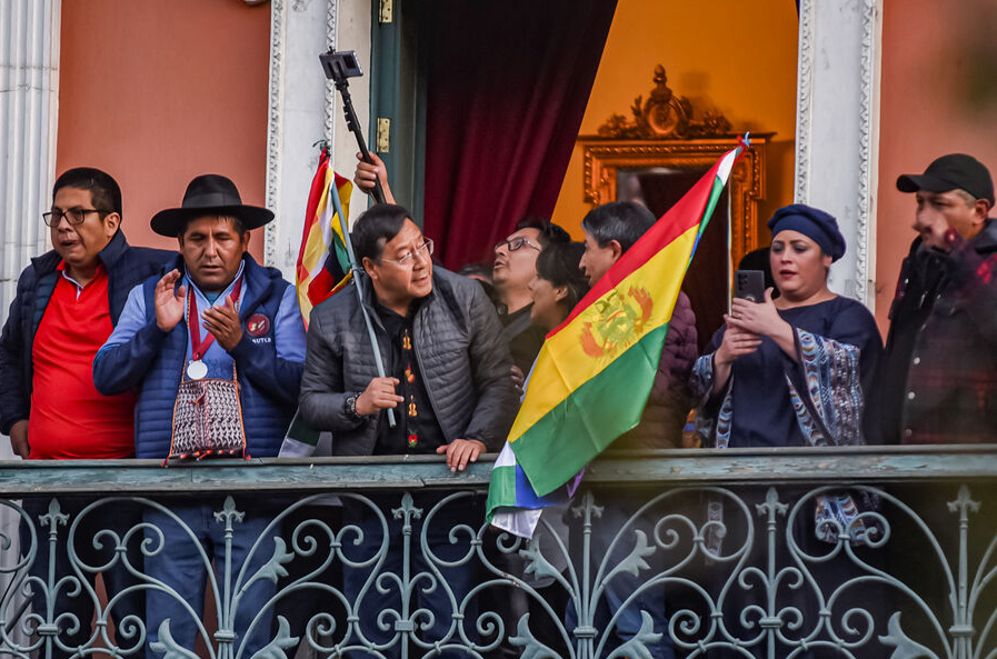 Президент Боливии Луис Арсе приветствует народ, вышедший на площадь в его поддержку.