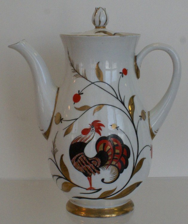 Кофейник с крышкой из сервиза "Детский". 1950. Автор формы Семёнов В.Л., автор росписи Щекатихина-Потоцкая А.В. Основной рисунок: "сказочная" птица из русских сказок - Петя-петушок, Золотой гребешок - с узорчатым обрамлением в виде веточек с фантазийными ягодами, внешне похожими на красную смородину (но листья явно не соответствуют). Федеральное государственное бюджетное учреждение культуры "Государственный Эрмитаж". Листайте галерею вправо.