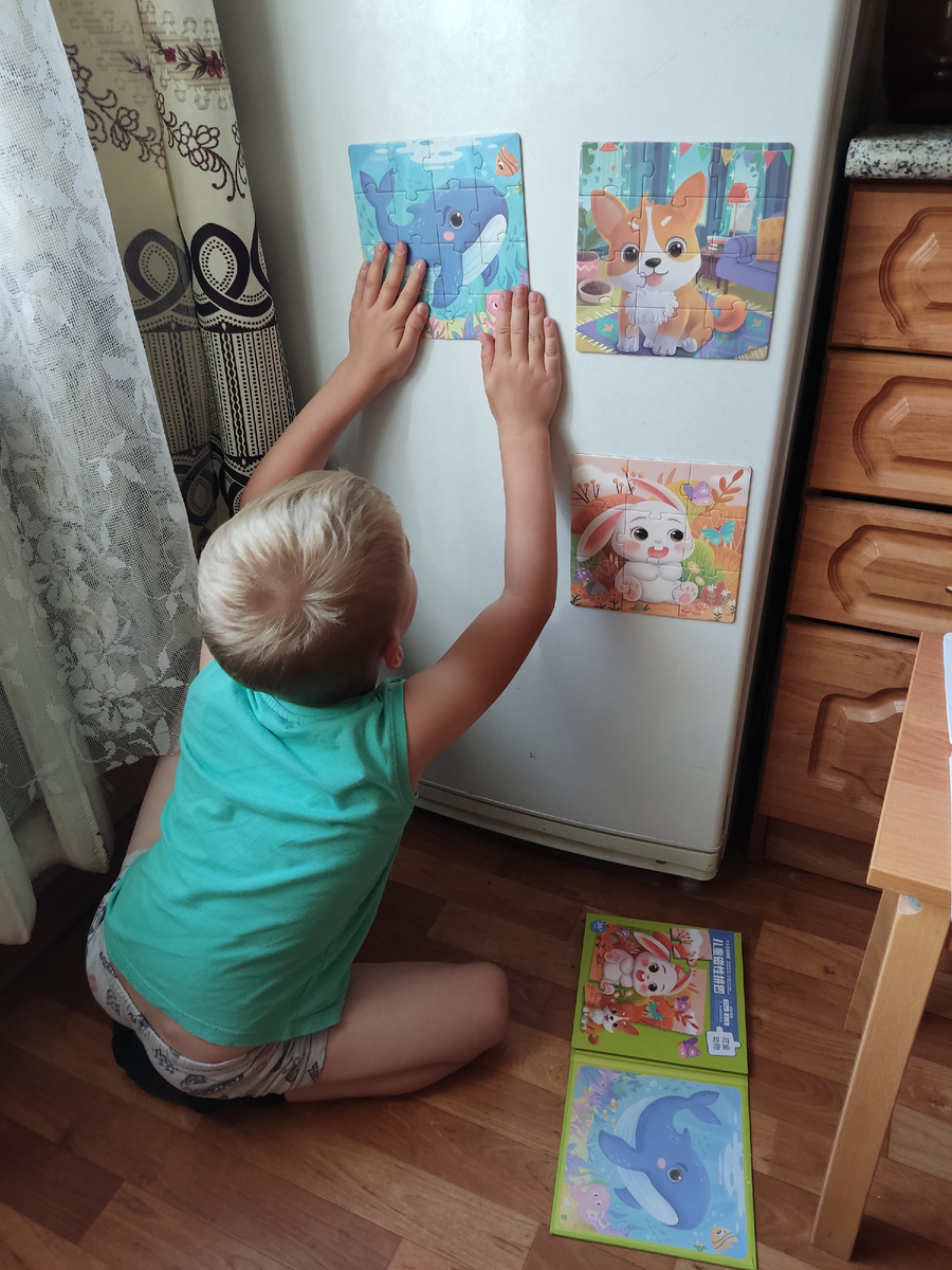 Ярик украшает холодильник. Просто собирать картинку в альбоме его не устраивает, надо обязательно сделать красоту в квартире!