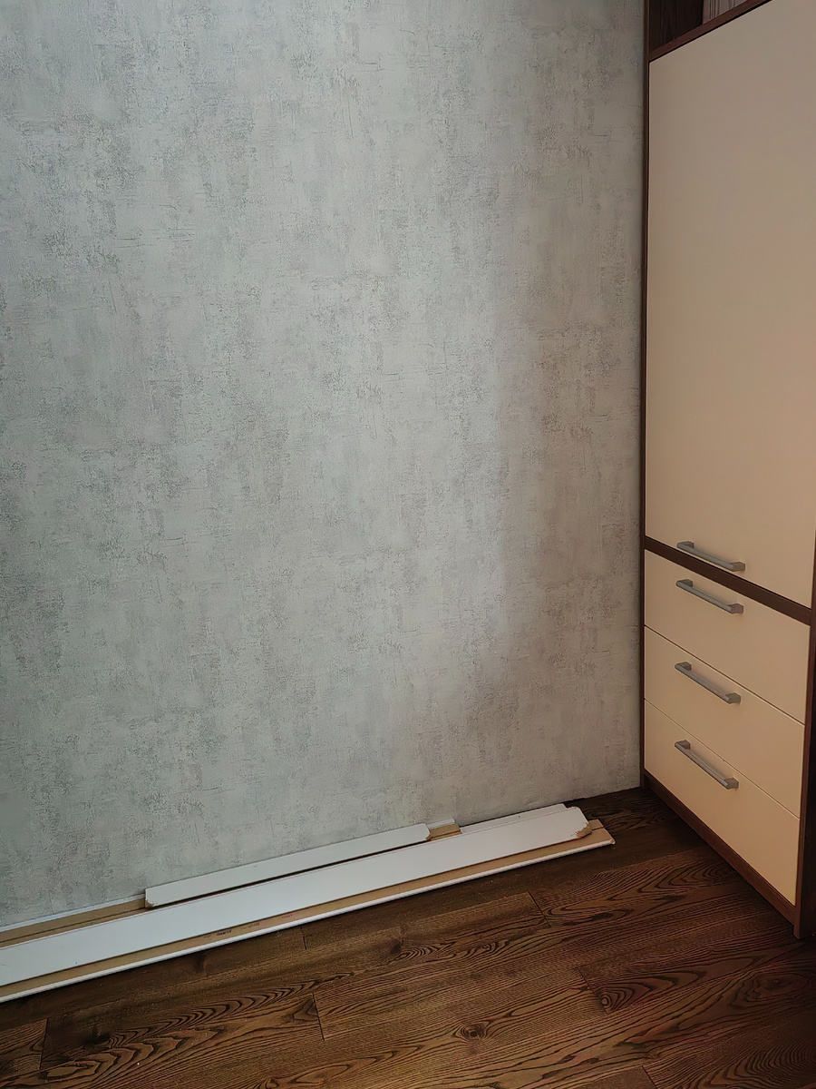 Недоделанной эта часть оказалась по моей вине: я планировала установить за дверь небольшой стеллаж по индивидуальным меркам. Поэтому, когда устанавливали плинтус в комнате, эта часть стены осталась «необилеченной». 