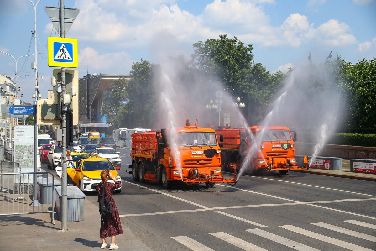    Полив раскаленного асфальта в жару спасает дороги от деформаций.