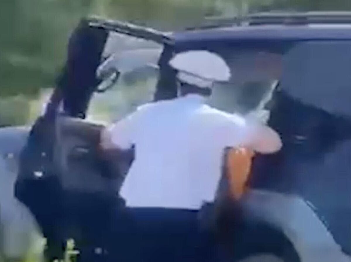    Сотрудник ДПС на ходу запрыгивает в машину, чтобы остановить неадекватного водителя на пляже в Красноярском крае. Кадр видео