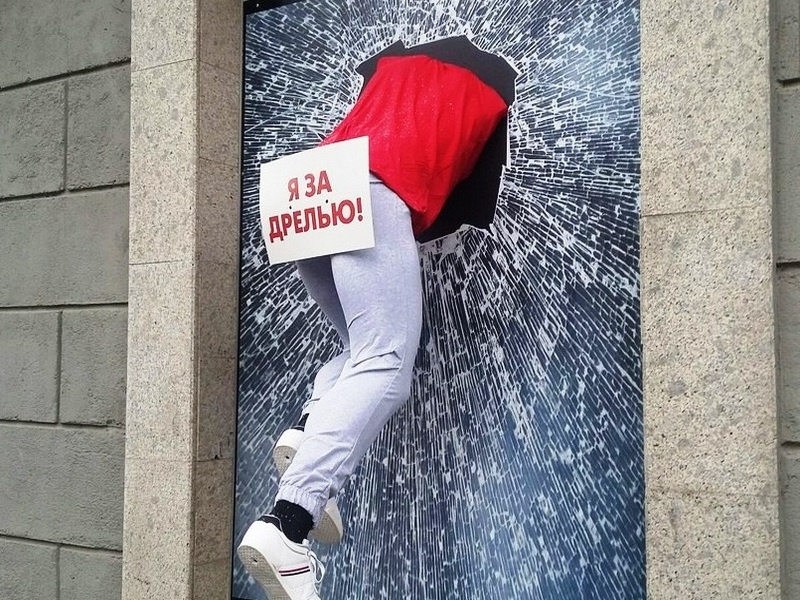 Эта наружная реклама изображает человека, прорвавшегося через стену, с табличкой "Я за дрелью!" и явно готового к самым мощным ремонтным приключениям. 