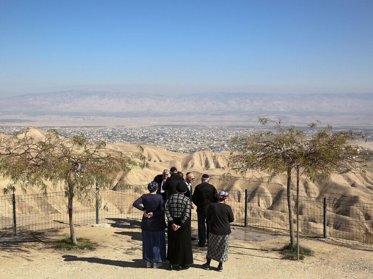    Израильские поселенцы стоят на смотровой площадке с видом на город Иерихон на Западном берегу реки Иордан© AP Photo / Oded Balilty