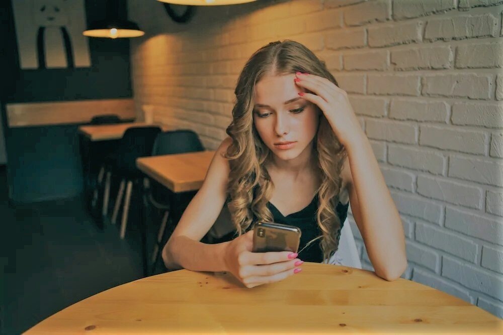 расстроенная девушка в кафе