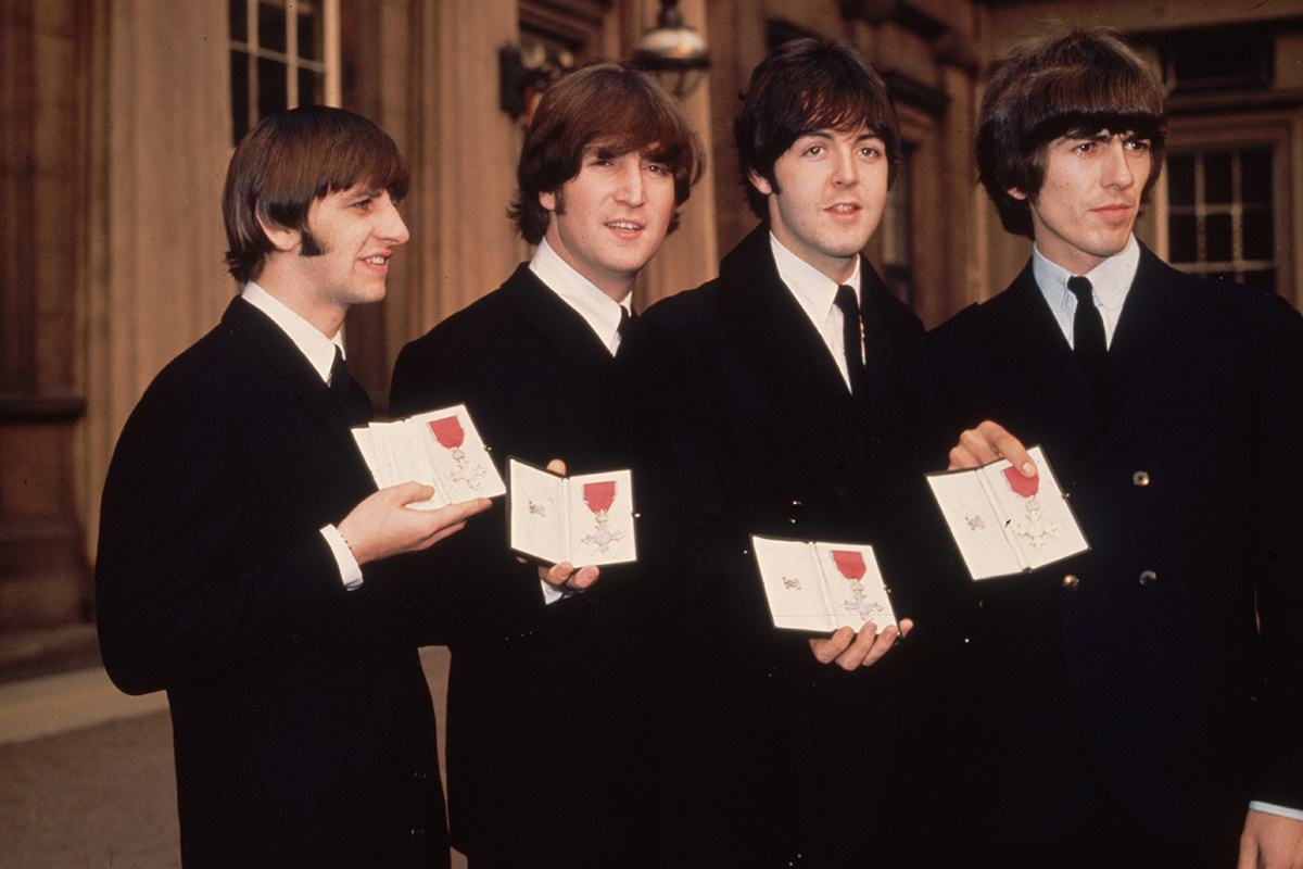 Fox Photos / Getty Images📷Британская поп-группа The Beatles (слева направо): Ринго Старр, Джон Леннон (1940–1980), Пол Маккартни и Джордж Харрисон (1943–2001). Перед Букингемским дворцом в Лондоне после получения степени магистра искусств (кавалера ордена Британской империи) от королевской семьи. 26 октября 1965 года