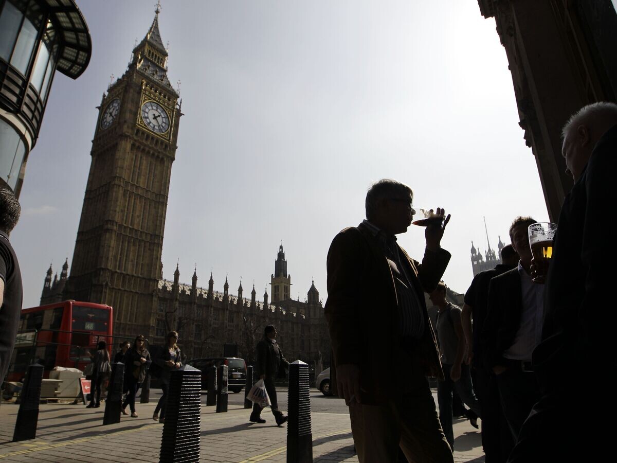    Люди пьют пиво напротив здания Парламента в Лондоне© AP Photo / Sang Tan