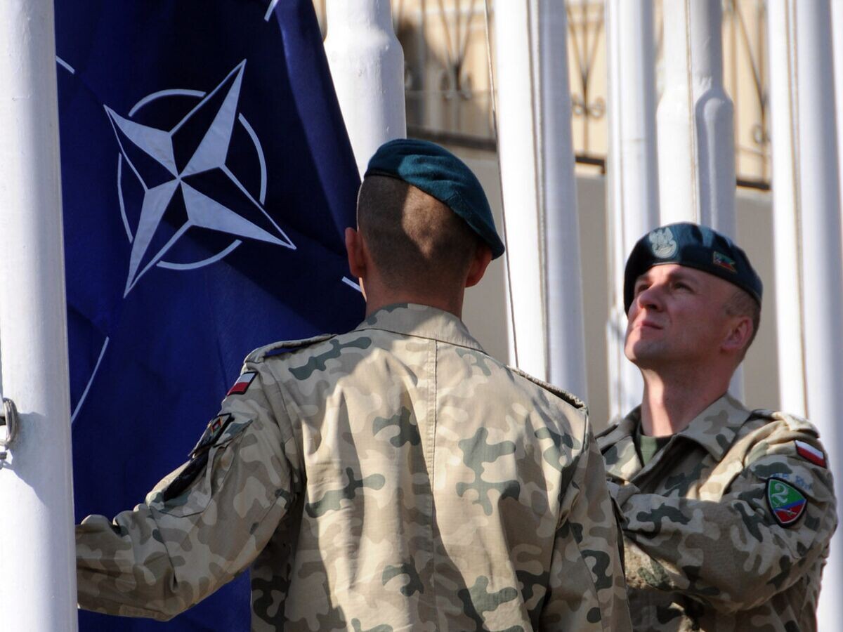    Военнослужащие поднимают флаг НАТО© Chief Petty Officer Julian Carroll