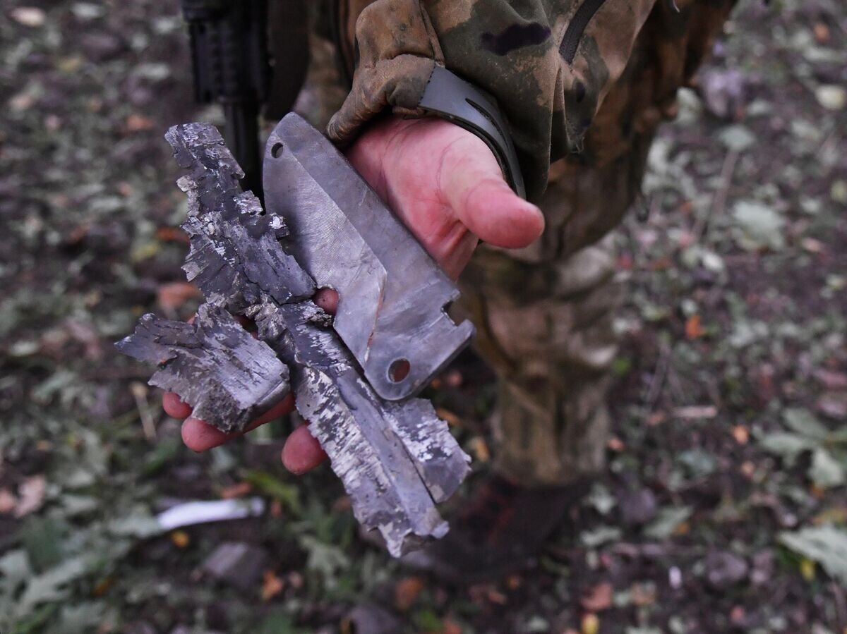    Боец демонстрирует осколки боеприпаса иностранного производства, выпущенного артиллерией ВСУ, на передовой на окраине Красного Лимана в ДНР© РИА Новости / Виктор Антонюк