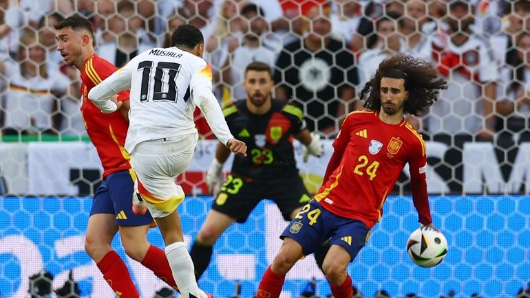    Мяч попал в руку Марка Кукурельи после удара Джамала Мусиалы в матче Испания — Германия. Reuters