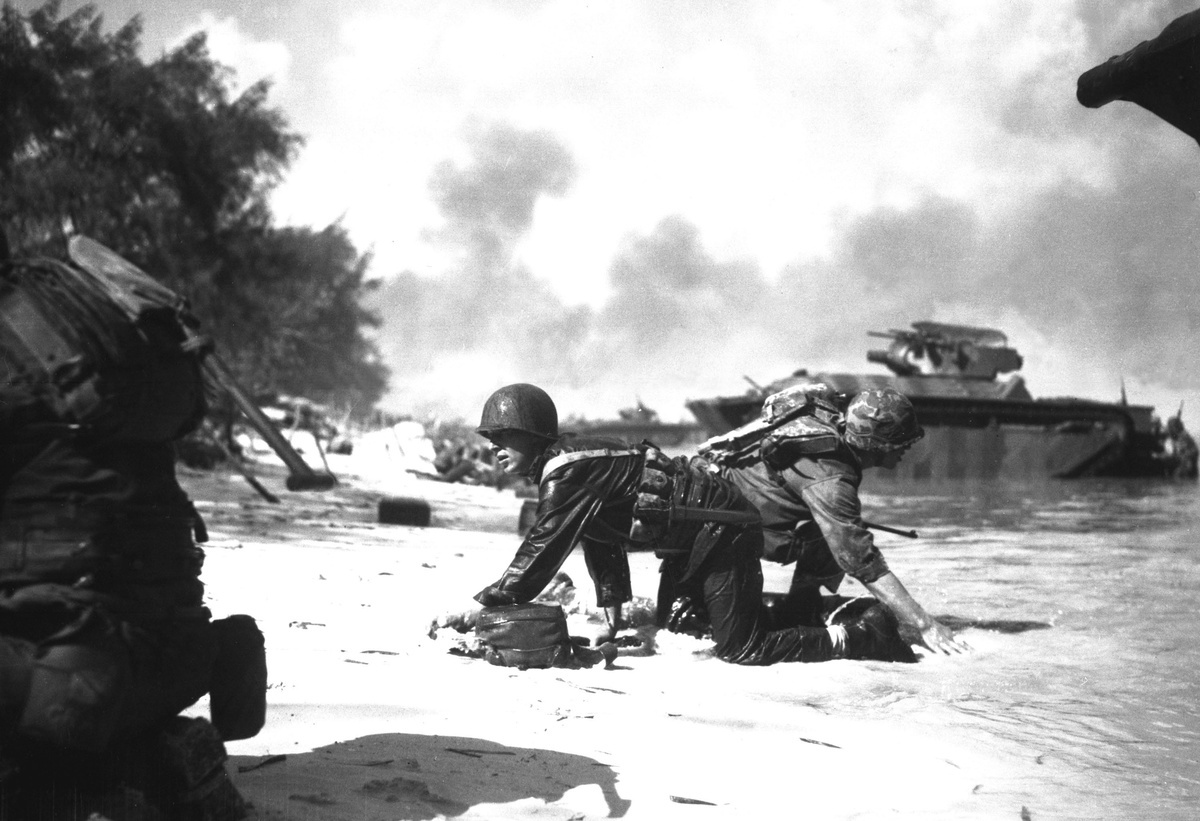 Американские морские пехотинцы высаживаются на остров Сайпан под огнём противника. В центре — сержант Джеймс Бернс. 15 июня 1944 года