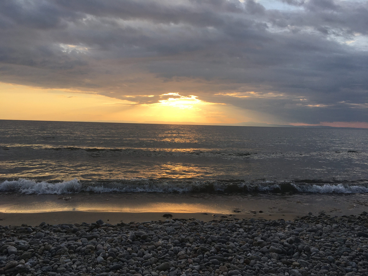 Встречаем закат на берегу Байкала. Вдалеке виднеется остров Ольхон