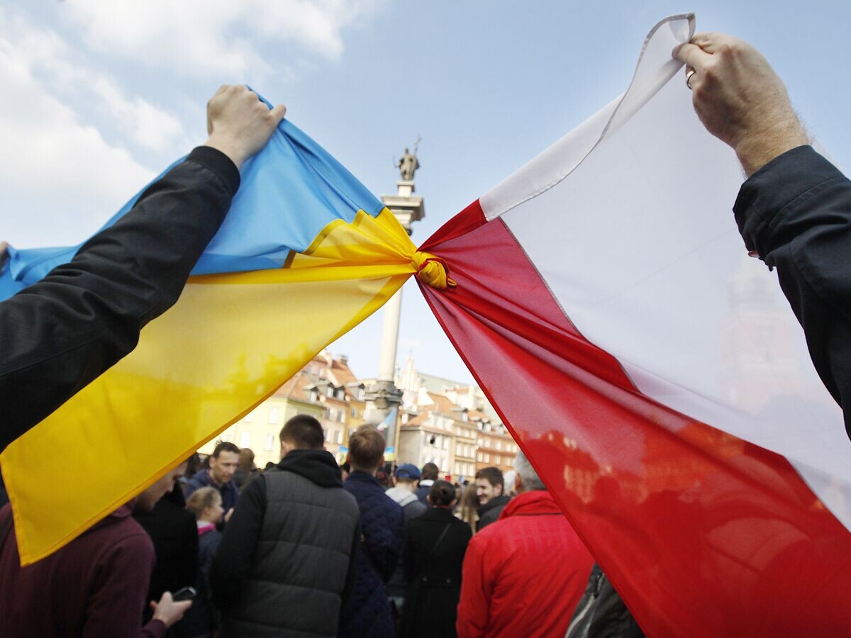    Люди держат связанные флаги Польши и Украины в Варшаве© AP Photo / Czarek Sokolowski