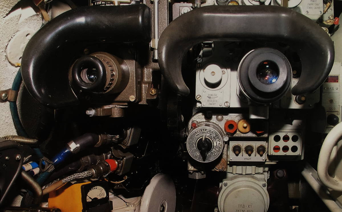 Под окуляром ТПД-К1 слева направо: переключатель типа боеприпаса; правее- переключатели механизма изменения дальности до цели, стабилизатора вооружения, приводов башни и пушки; далее блок сигнальных ламп. Внизу- пульт наведения ( "Чебурашка"). Прямоугольный блок правее налобника прицела с индикатором красного цвета- блок измерения дальности. Ниже ночного прицела виден визуальный указатель количества выстрелов в транспортере АЗ и ручной механизм поворота башни. Левее окуляра ТПД-К1- маховик регулировки подсветки шкалы. Фото: Tomash Bouchal.